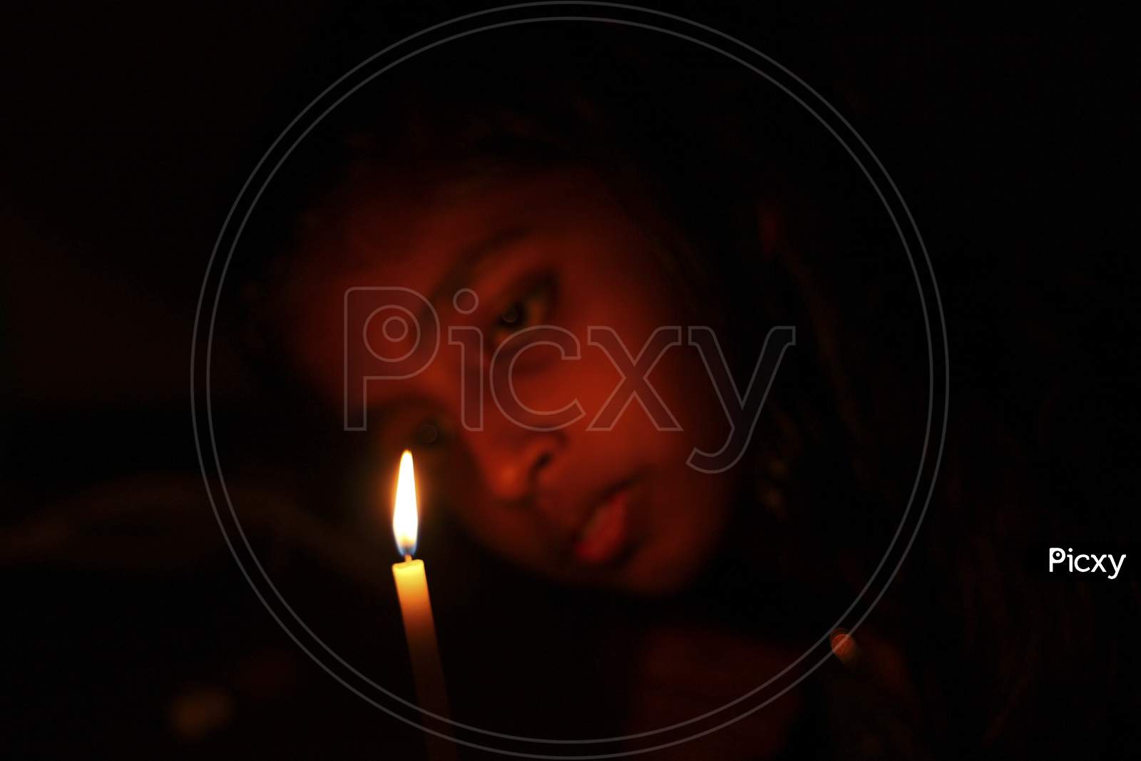Girl Looking On A Candle Flame In Sad Mood