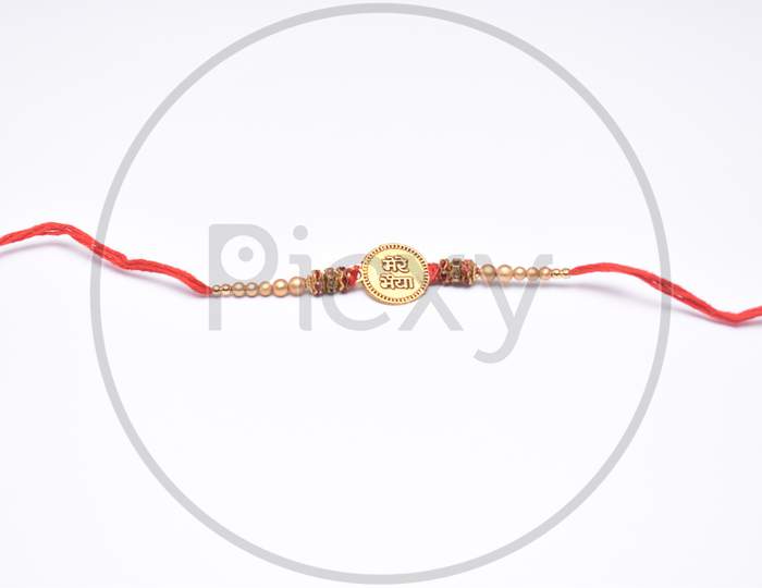 Raksha Bandhan, Indian Festival With Beautiful Rakhi On White Background. A Traditional Indian Wrist Band Which Is A Symbol Of Love Between Sisters And Brothers.
