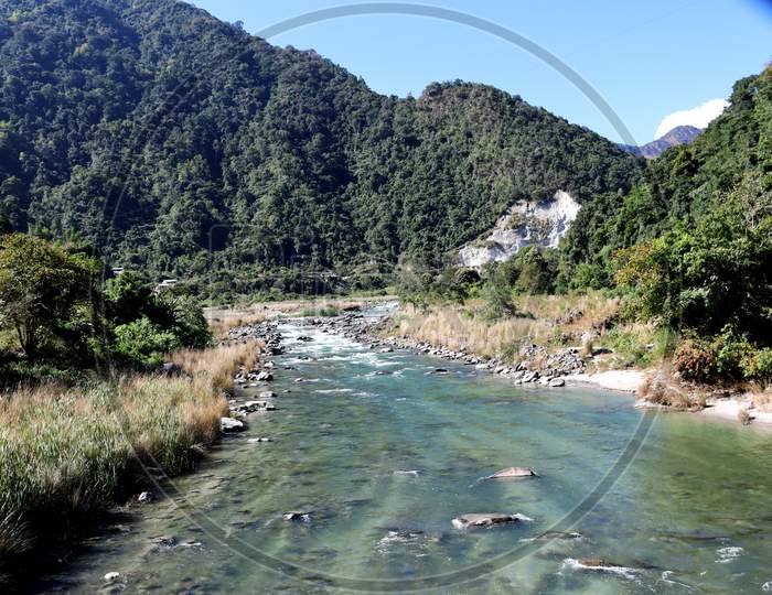 Kameng River Flowing Through Forested Valley Of Himalaya Near Bomdila, Arunachal Pradesh, India.Sunny Morning With Blue Sky.River Flow Through Rock.