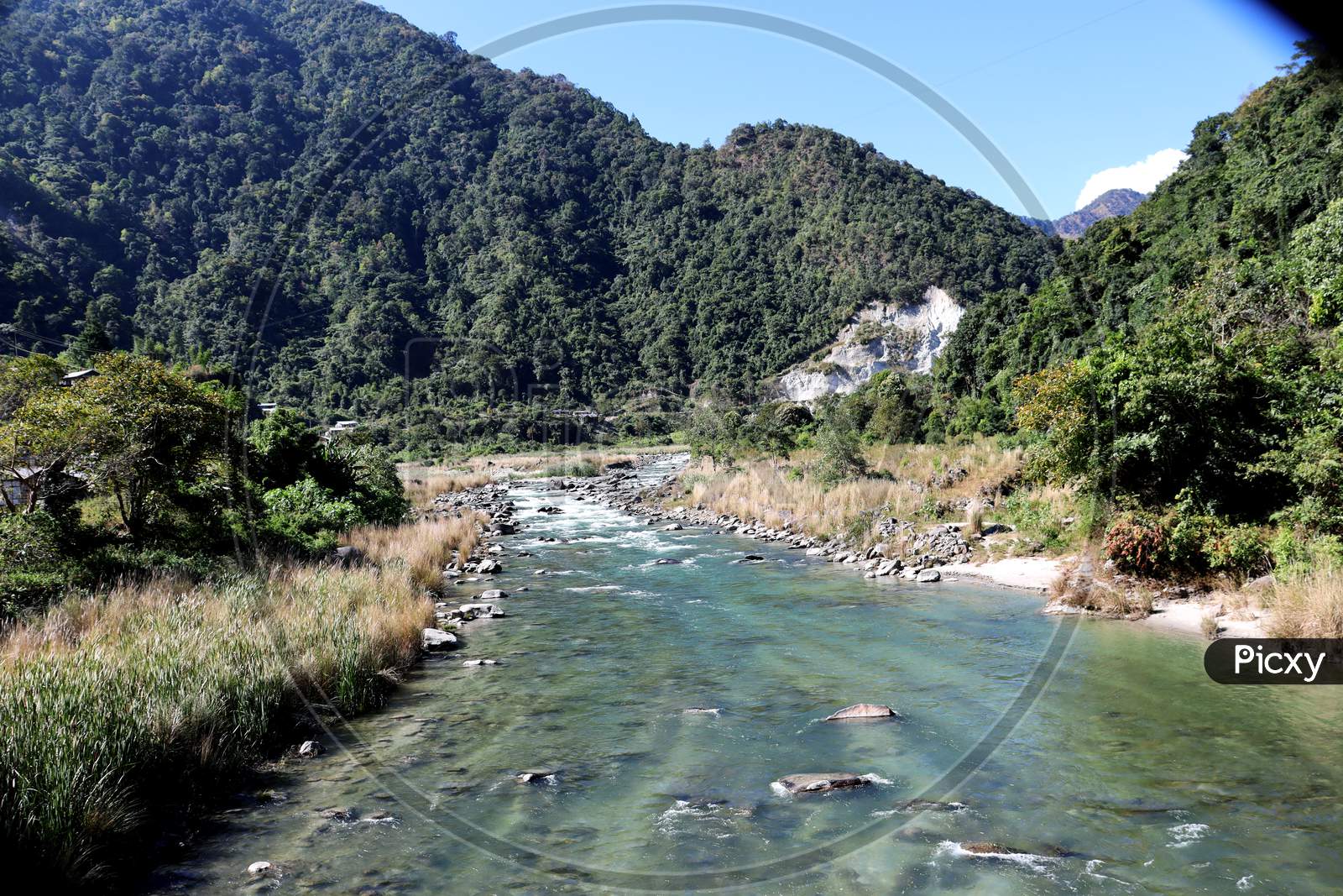 Kameng River Flowing Through Forested Valley Of Himalaya Near Bomdila, Arunachal Pradesh, India.Sunny Morning With Blue Sky.River Flow Through Rock.