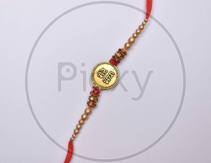 Closeup Shot Of Rakhi With Bhai (Brother) Written On It And Decorated With Beads On White Background