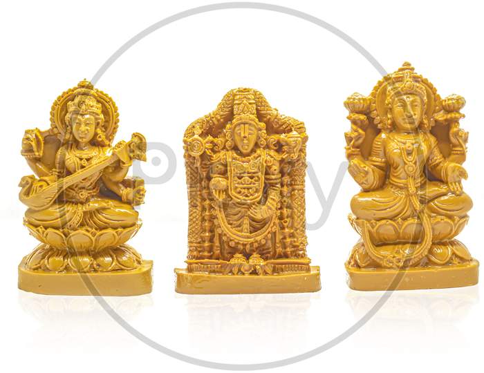 The Wood Carved Idols Of Mahalakshmi, Saraswati And Venkateswara Swamy Are Isolated With White Background.