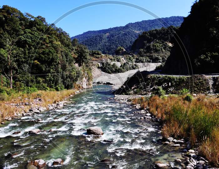 Kameng River Near Road Side Flowing Through Forested Valley Of Himalaya Bomdila, Arunachal Pradesh, India.Sunny Morning With Blue Sky.River Flow Through Rock.