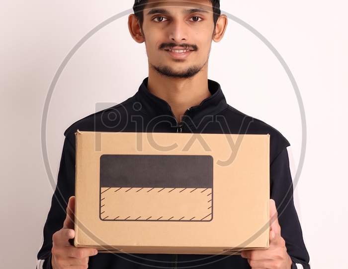 unshaven Indian courier boy with brown box wearing black t-shirt with facial expressions isolated on white background