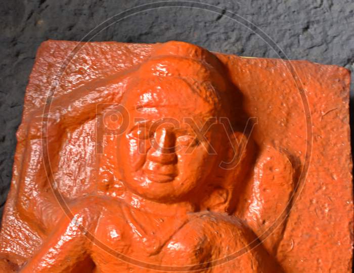 orange colour statue in ancient lonad cave, maharashtra