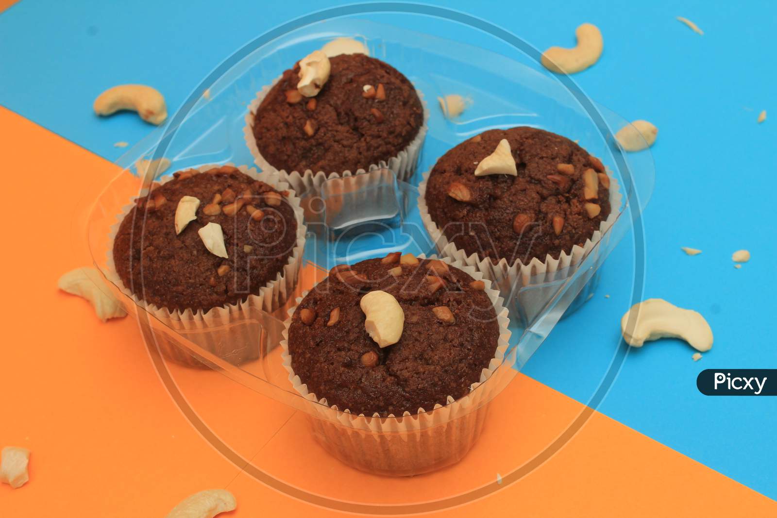 Chocolate Muffin Isolated On Color Background. Delicious Chocolate Muffin With Nuts.