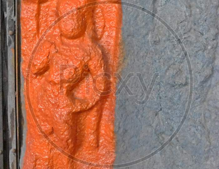 orange colour statue in ancient lonad cave, maharashtra