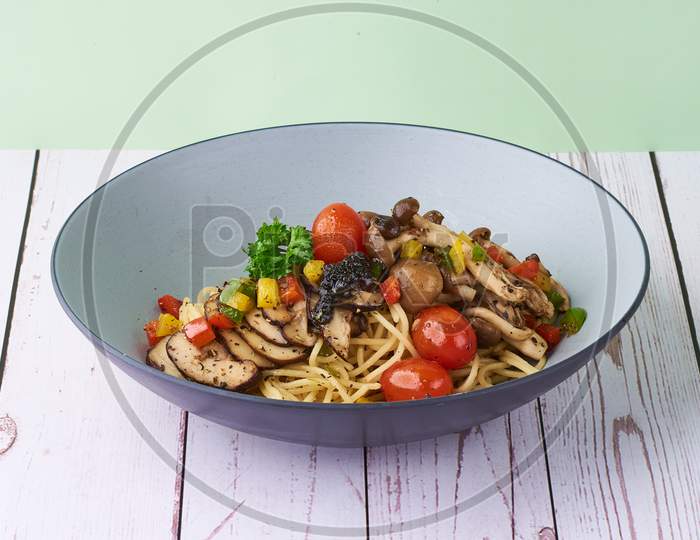 Pasta Truffle Aglio Oglio With Mushroom And Tomatoes In A Bowl On Wooden Background