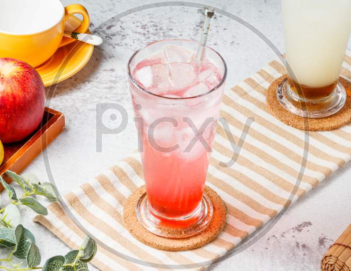 Love Sakura Sparkling Water In Glass With Ice Cubes On Mat And White Background. Fresh Healthy Drinks Concept