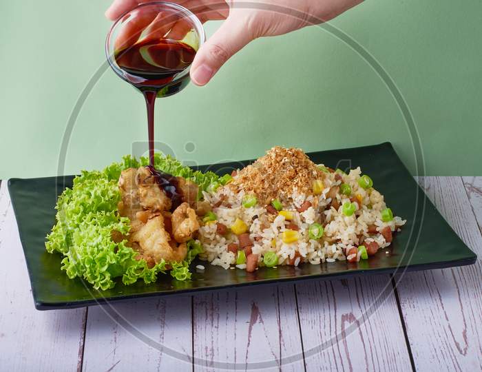 Traditional Chinese Food Fried Rice Yang Zhou With Abalone Mushroom And Teriyaki Sauce In Black Tray On Wood Table Background