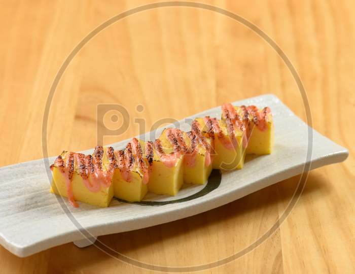 Japanese Food Tamagoyaki In A White Dish Isolated On Wooden Table Top View