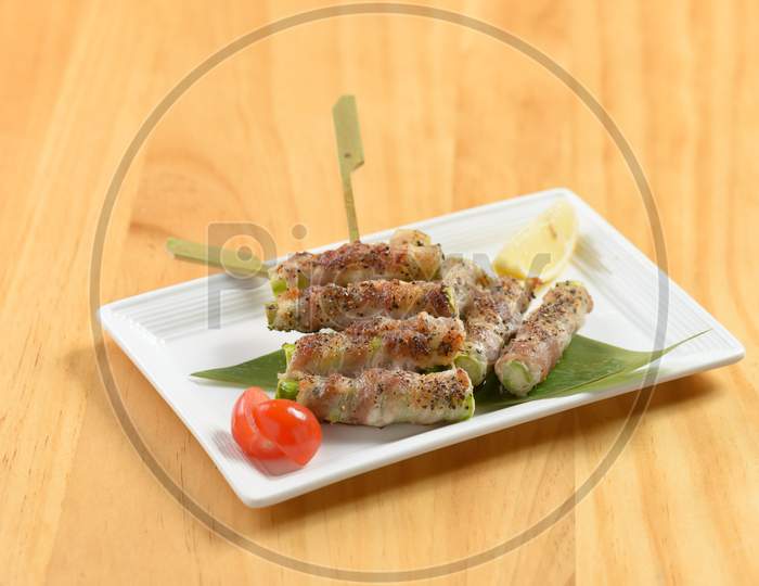 Japanese Food Aspara Bacon-Wrapped Asparagus Rolls In A White Tray Side View On Wooden Background