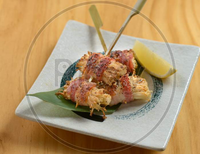 Crispy Deep Fried Enoki Mushrooms Sticks On Banana Leaf On White Plate Isolated On Wooden Background Top View