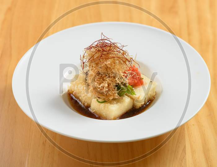 Japanese Food Agedashi Tofu Served In Flavorful Tsuyu Sauce In A White Bowl Top View On Wood Background