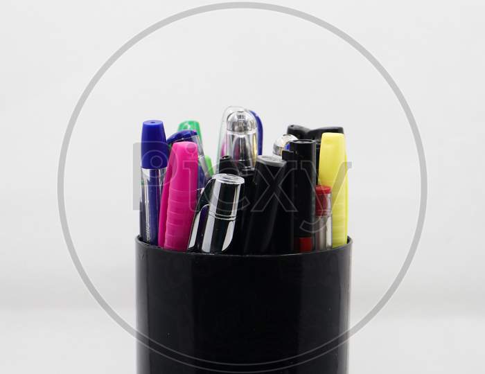 different varieties of gel, ball and colorful pens in a black pen holder