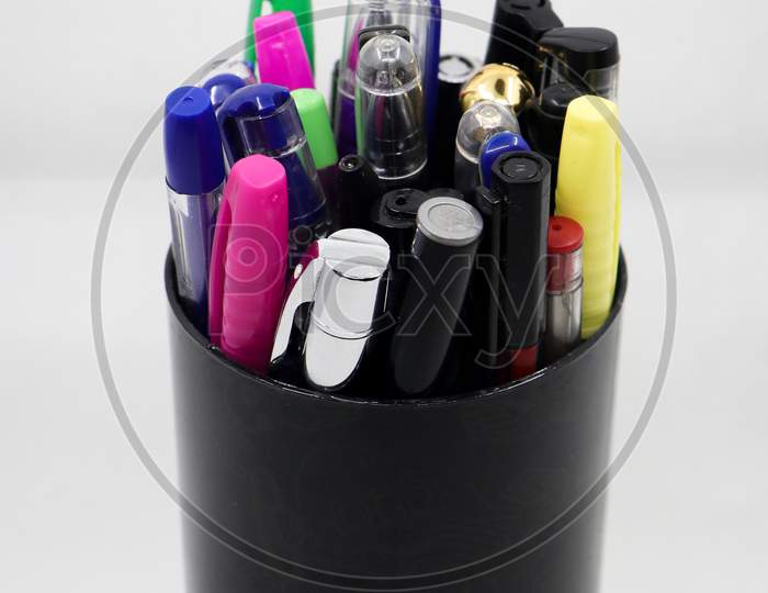 different varieties of gel, ball and colorful pens in a black pen holder