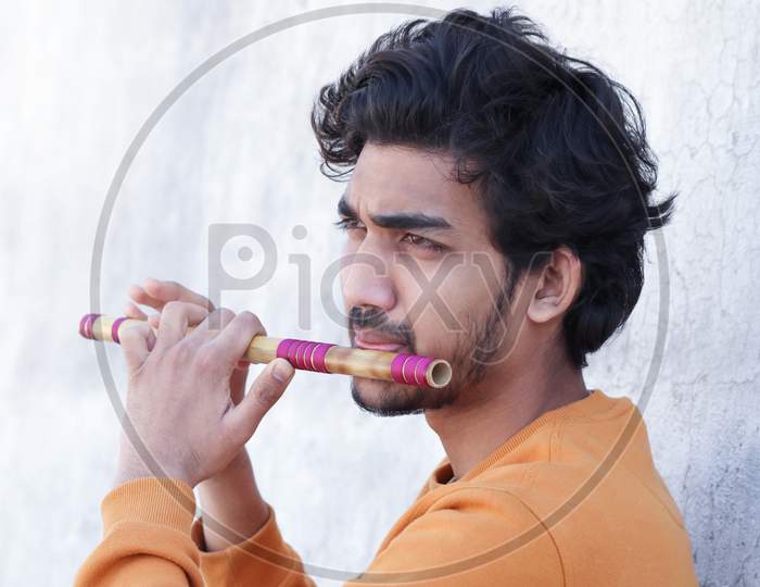Indian Boy Playing Bansuri Indian Bamboo Flute.