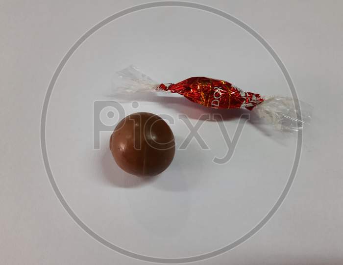 Closeup Of Milk Chocolate Lindor Truffles With Soft Centers. Wrapped In Red Foil And Made By Lindt Chocolate Of Switzerland Isolated On White Background