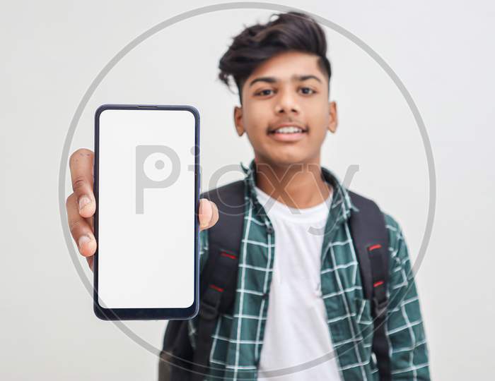 Young Indian College Student Showing Smartphone Screen On White Background.