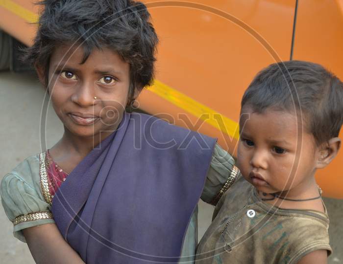 Girl beggar with small kid